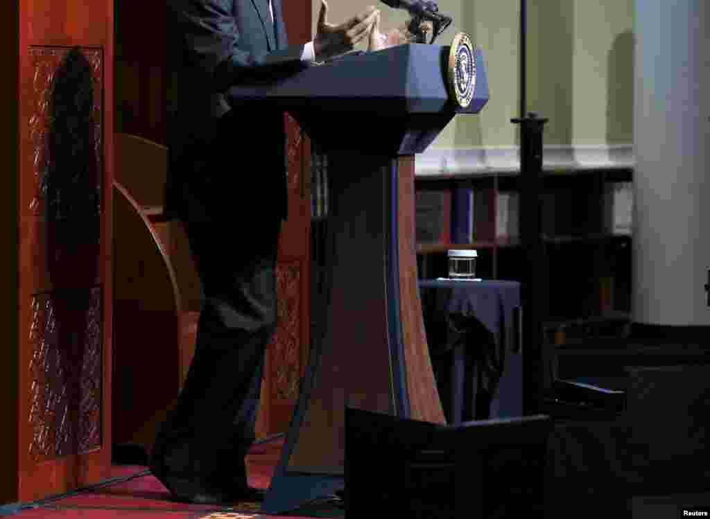 President Barack Obama goes without shoes, out of deference, as he delivers remarks at the Islamic Society of Baltimore mosque in Catonsville, Md., Feb. 3, 2016. 