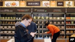 FILE - Shoppers roam through an Amazon Go store, currently open only to Amazon employees, in Seattle, Washington, April 27, 2017.