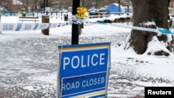 Flowers are left at the cordon near the tent covering the park bench where former Russian intelligence officer Sergei Skripal and his daughter Yulia were found poisoned in Salisbury, Britain, March 19, 2018. 