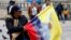 A woman sells flags with the image of Pope Francis outside the Cathedral of Bogota in Bolivar Square, Colombia, Sept. 2, 2017.