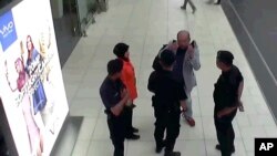 FILE - Kim Jong Nam, exiled half brother of North Korea's leader Kim Jong Un, gestures toward his face while talking to airport security and officials at Kuala Lumpur International Airport, Malaysia, in this image made Feb. 13, 2017.