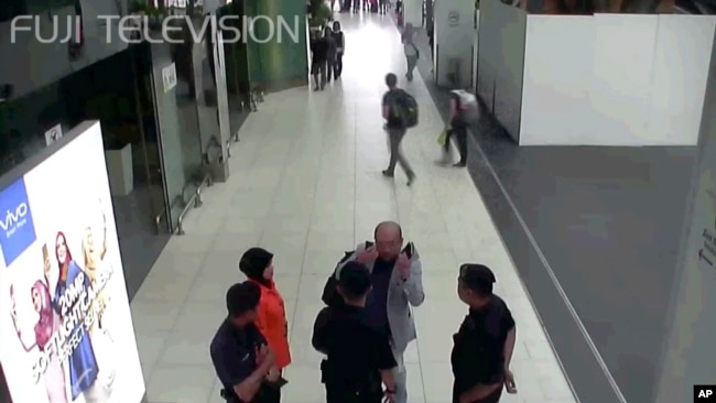 FILE - Kim Jong Nam, exiled half brother of North Korea's leader Kim Jong Un, gestures toward his face while talking to airport security and officials at Kuala Lumpur International Airport, Malaysia, in this image made Feb. 13, 2017, from Kuala Lumpur airport security cameras.
