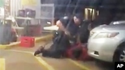 In this July 5, 2016, photo made from video, Alton Sterling is held by two Baton Rouge police officers, with one holding a hand gun, outside a convenience store in Baton Rouge, Louisiana.