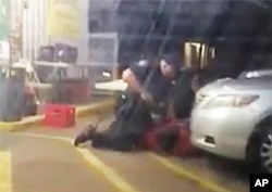 In this July 5, 2016, photo made from video, Alton Sterling is held by two Baton Rouge police officers, with one holding a hand gun, outside a convenience store in Baton Rouge, Louisiana.
