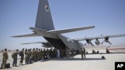 FILE - Afghan National Army soldiers line up to get into a C-130 Hercules at Kandahar Air Base in Kandahar, Afghanistan, Aug. 18, 2015.