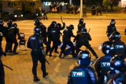 Police use truncheons on protesters during a mass protest following presidential election in Minsk, Belarus, Monday, Aug. 10, 2020.