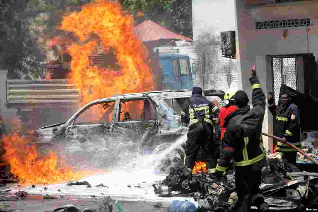 Somali firemen try to extinguish burning cars at the scene of a car bomb attack in front of a restaurant in Mogadishu.