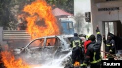 Des pompiers somaliens tentent d'éteindre le feu sur le lieu de l'explosion d'une voiture piégée devant un restaurant à Mogadiscio en Somalie 29 janvier 2019