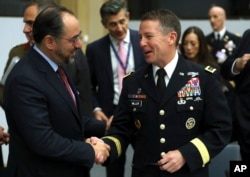 NATO-led Resolute Support Mission Commander, U.S. Army General Austin Scott Miller, right, shakes hands with Afghanistan's Foreign Minister Salahuddin Rabbani during a meeting at NATO headquarters in Brussels, Belgium, Dec. 5, 2018.