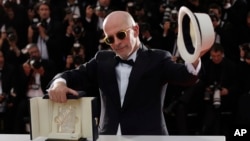 Director Jacques Audiard holds the Palme d’Or award for the film Dheepan as he poses for photographers during a photo call following the awards ceremony at the 68th international film festival, Cannes, southern France, Sunday, May 24, 2015.