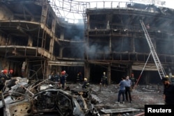 People gather at the site of a suicide car bomb in the Karrada shopping area, in Baghdad, Iraq, July 3, 2016.