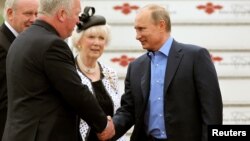 El presidente ruso Vladimir Putin (derecha) es recibido a su llegada al aeropuerto internacional de Belfast.