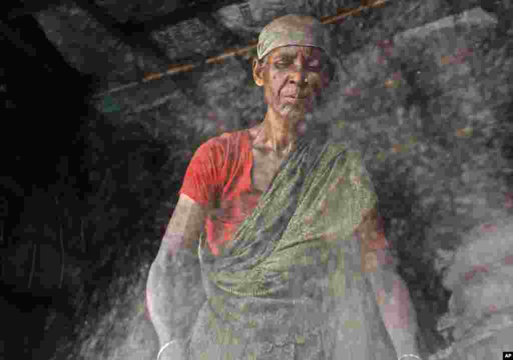 A Bangladeshi woman works at a recycling center in Dhaka, June 15, 2013.