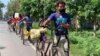 Pekerja migran India naik sepeda dalam perjalanan mudik ke kampung halaman mereka selama diberlakukannya pembatasan akibat pandemi COVID-19 tahun 2020. (Foto: Bhagirathi Films / Thomson Reuters Foundation)