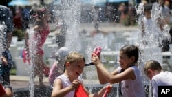 Children play in the fountain in the scorching heat at the Australian Open tennis championship in Melbourne, Australia, Thursday, Jan. 16, 2014. 