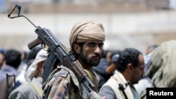 在也门首都萨那，胡塞反政府武装成员持枪参加集会。