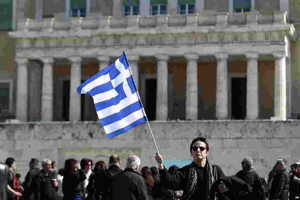 A woman raises a Greek flag during an anti-austerity rally in front of the parliament in Athens, February 19, 2012. (Reuters)