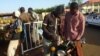 Un homme achète de l'essence au marché noir pour sa moto dans le quartier Lazaret de Niamey, le 5 janvier 2012. 