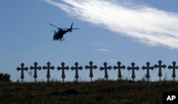 A law enforcement helicopter flies over crosses placed near the scene of a shooting at the First Baptist Church of Sutherland Springs in Sutherland Springs, Texas, Nov. 6, 2017.
