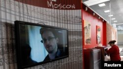 မော်စကိုလေဆိပ်က ဈေးဆိုင်တခုမှာ Snowden အကြောင်း သတင်းလာနေစဉ်။ (ဇူလိုင်လ ၂၆ ရက်၊ ၂၀၁၃)။