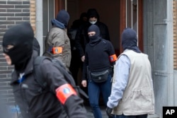 Belgian police leave after an investigating in a house in the Anderlecht neighborhood of Brussels, Belgium, March 23, 2016, one day after Tuesday's deadly suicide attacks on the Brussels airport and its subway system.