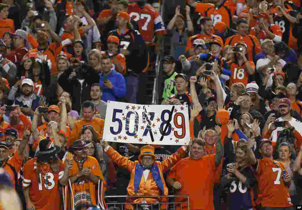 Denver Broncos fans celebrate Peyton Manning's 509th career touchdown pass during the first half of an NFL football game against the San Francisco 49ers in Denver, Oct. 19, 2014.