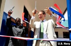 FILE - U.S. Ambassador to Tanzania, Mark Green, right, cuts a ribbon during a dedication ceremony at Jitegemee Secondary School in Dar es Salam, Tanzania, Dec. 18, 2008.