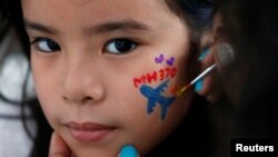 Seorang anak perempuan dilukis wajahnya dalam acara peringatan empat tahun hilangnya pesawat Malaysia Airlines MH370, di Kuala Lumpur, Malaysia, 3 Maret 2018.