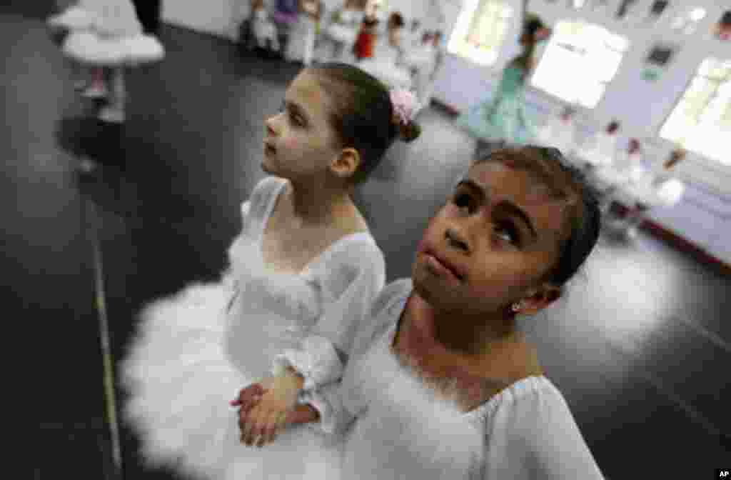 Deaf ballet student Raissa Goncalves (L) and her blind classmate Vitoria Rodrigues rehearse Don Quixote at the Association of Ballet and Arts for the Blind, in Sao Paulo November 19, 2011. The Association was founded by ballerina and physiotherapist Ferna