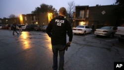 U.S. Immigration and Customs Enforcement agents enter an apartment complex looking for a specific undocumented immigrant convicted of a felony during an early morning operation in Dallas, March 6, 2015,.