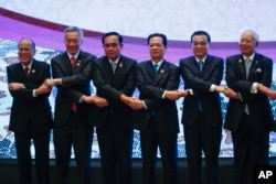 FILE - Vietnam's Prime Minister Nguyen Tan Dung, third from right, chains hands with other leaders during the 10th China-ASEAN Summit in Kuala Lumpur, Malaysia, on Nov. 21, 2015.