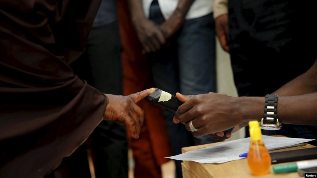 Seorang petugas tengah memeriksa sidik jari salah seorang pemilih di Daura, barat laut Nigeria, 28 Maret 2015 (REUTERS/Akintunde Akinleye)