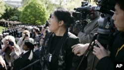 2006年4月20日，《大纪元》记者、法轮功修炼者王文怡在中国国家主席胡锦涛与布什总统在白宫南草坪会晤仪式上，从摄影人员站台上大声喊话。
