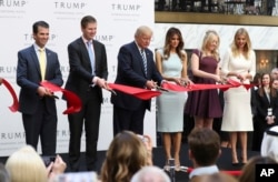 Republican presidential candidate Donald Trump, together with his family, from left, Donald Trump Jr., Eric Trump, Trump, Melania Trump, Tiffany Trump and Ivanka Trump, cut the ribbon during the grand opening of Trump International Hotel in Washington, D.C., Oct. 26, 2016.