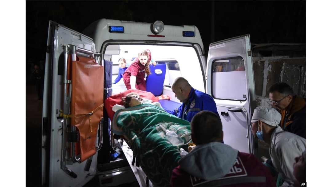 Medics load an injured person into an ambulance, in Kerch, Crimea, Oct. 17, 2018, following a shooting rampage at a vocational college.