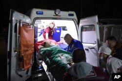 Medics load an injured person into an ambulance, in Kerch, Crimea, Oct. 17, 2018, following a shooting rampage at a vocational college.