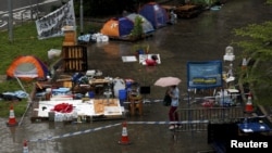 A passerby walks past tents, before they are removed, outside the government headquarters in Hong Kong, China, June 24, 2015.