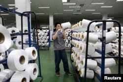FILE - An employee works inside a textile mill in Yiwu, Zhejiang province, China.