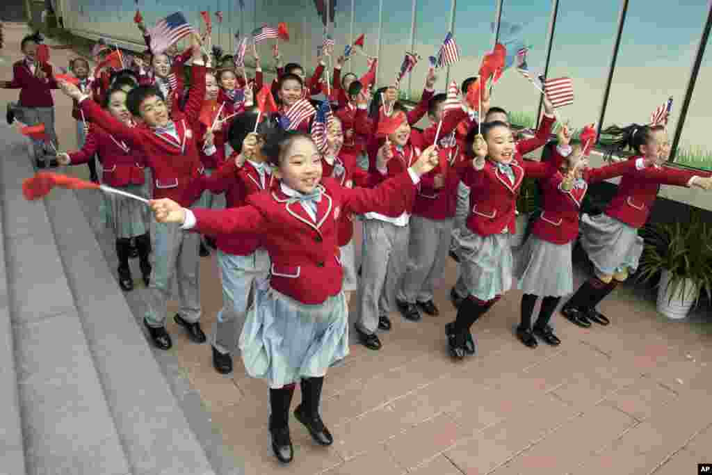 Estudantes chineses exibem bandeira chinesas e dos Estados Unidos aquando da visita das primeira-damas Melania Trump e Peng Liyuan à escola primária Banchang em Pequim. 9 Novembro, 2017