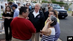 President Donald Trump talks to residents while taking a walking tour to survey hurricane damage and recovery efforts in a neighborhood in Guaynabo, Puerto Rico, Oct. 3, 2017. 