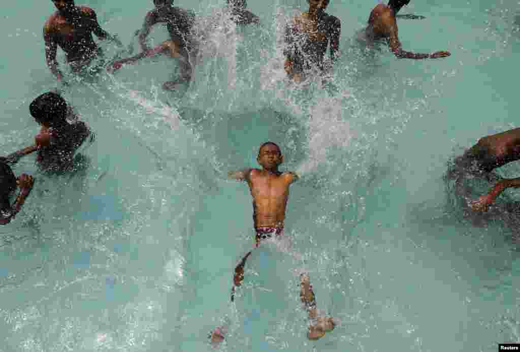 A boy jumps into a swimming pool to cool himself on a hot day in the southern Indian city of Chennai.