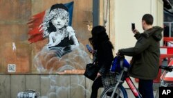 Une oeuvre murale de l'artiste britannique Banksy en face de l'ambassade de France à Londres. 25 janvier 2016 (AP Photo/Alastair Grant)