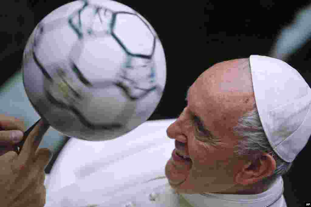 프란치스코 교황이 바티칸에서 열린 미사 중 이탈리아축구협회 회원들 앞에서 축구공을 돌리고 있다.
