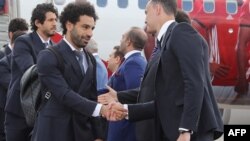 Le joueur de football de l'équipe nationale égyptienne et l'attaquant vedette de Liverpool, Mohamed Salah, se serrent la main en arrivant avec son équipe à l'aéroport international de Grozny, le 10 juin 2018.