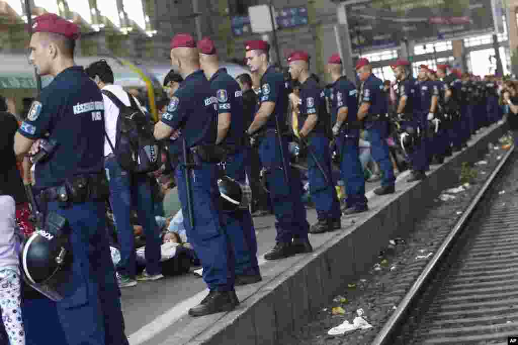 Para migran dan polisi menunggu di dalam Stasiun Kereta Api Keleti di Budapest, Hungaria (3/9). Para migran tidak diizinkan memasuki stasiun, meski kereta-kereta langsung dari Budapest ke Eropa Barat saat ini tidak beroperasi sampai pemberitahuan selanjutnya.