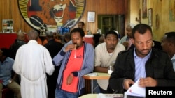 Customers drink coffee as they read newspapers at the Tamoka coffee bar in Ethiopia's capital Addis Ababa, Sept. 16, 2013. 