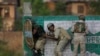 Các binh sĩ bán quân sự Ấn Độ nấp sau một bức tường trong các cuộc xung đột với những người ném đá Kashmir tại Srinagar, thuộc vùng Kashmir do Ấn Độ kiểm soát.