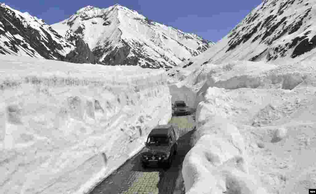 Kendaraan melalui celah Zojila yang diselimuti salju, 108 kilometer (67 mil) sebelah timur Srinagar, ibu kota musim panas Kashmir India, 30 April 2016.