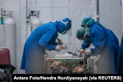 Petugas kesehatan merawat pasien COVID-19 di tenda darurat RS Sardjito saat terjadi kelangkaan oksigen di Sleman, Yogyakarta di tengah perebakan varian delta, 4 Juli 2021. (Foto: Antara Foto/Hendra Nurdiyansyah via REUTERS)