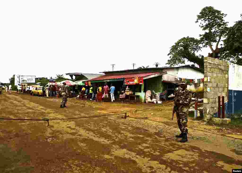 Para tentara angkatan darat Liberia mengawasi pos pemeriksaan di perbatasan sebagai bagian dari Operasi Tameng Putih untuk mengontrol wabah Ebola, di pintu masuk ke Bomi County, di Liberia barat laut. (Reuters/Sabrina Karim)